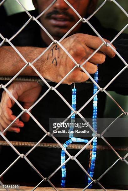Prisoner holds his religious beads as he is processed and released from Abu Ghraib prison on July 15, 2004 west of Baghdad, Iraq. Many of the...