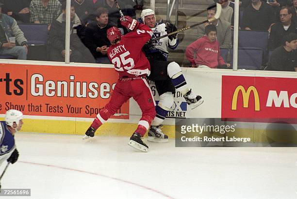 Mattias Norstrom of the Los Angeles Kings is Smashed by Darren McCarty of the Detroit Red Wings during the Western Conference Quarter Finals game at...
