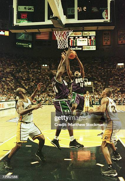 Robert Traylor and Glenn Robinson of the Milwaukee Bucks battle for a rebound against Dale Davis and Antonio Davis of the Indiana Pacers during game...