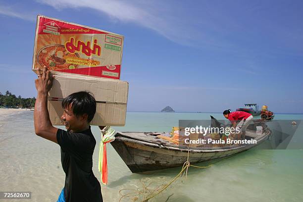 Food supplies are unloaded off of a longtail boat as Thai residents along the beach restock restaurants on the beach hoping for toursits to return...