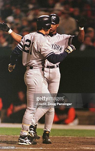 Darryl Strawberry of the New York Yankees congratulates teammate Paul O'Neill after O'Neill hit a home run against the Baltimore Orioles in the...