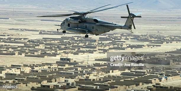 Super Stallion helicopter flies over a town near Kabul March 14, 2002 after refueling Marine Cobra helicopters near the Shah-e-Kot valley in eastern...