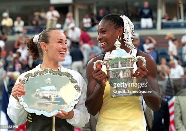 Serena Williams of the USA and Martina Hingis of Switzerland smile and pose with their trophies after their match in the US Open at the USTA National...