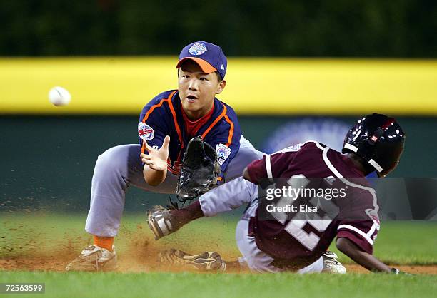 Yuki Mizuma of Asia is unable to tag out Sorick Liberia of the Caribbean as he steal second during the International Final of the Little League World...