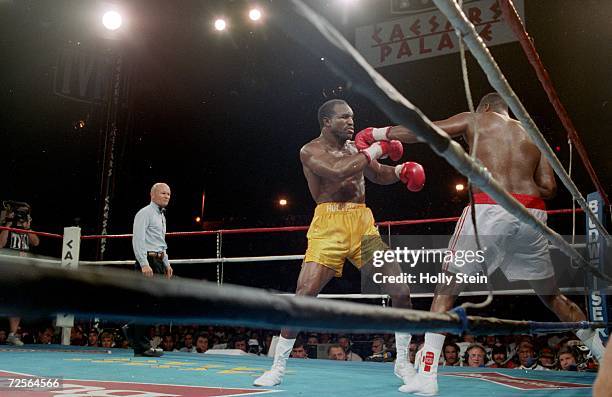 Evander Holyfield misses a punch as be back Larry Holmes into the ropes at Caesars Palace in Las Vegas, Nevada. Mandatory Credit: Holly Stein...