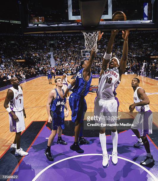 Forward Jerome Williams of the Toronto Raptors shoots the ball over guard Tracy McGrady of the Orlando Magic during the NBA game at the Air Canada...