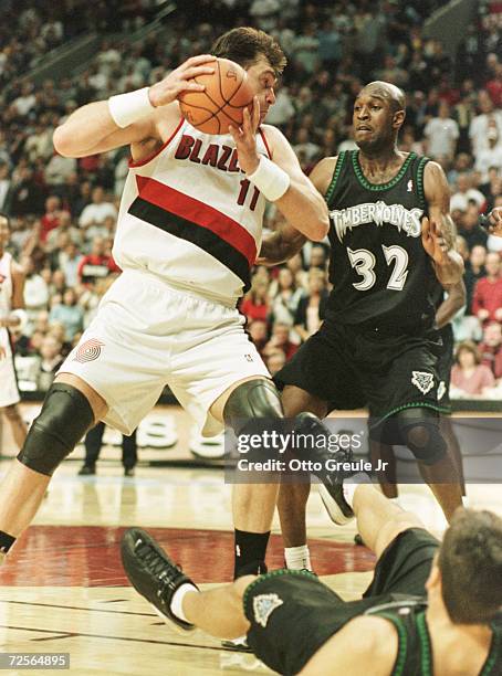 Arvydas Sabonis the Portland Trail Blazers knocks over Wally Szczerbiak as he drives to the basket against Joe Smith of the Minnesota Timberwolves....