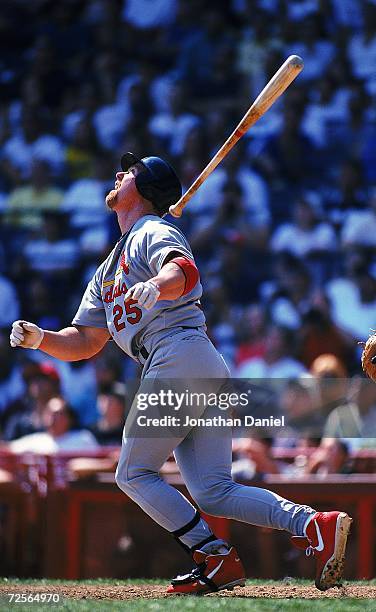 Mark McGwire of the St. Louis Cardinals throws the bat to run during the game against the Milwaukee Brewers at the County Stadium in Milwaukee,...