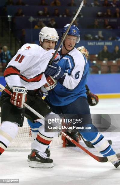 Ossi Vaananen of Finland holds onto Eric Lindros of Canada during the men's quarterfinals at the Salt Lake City Winter Olympic Games at the E Center...