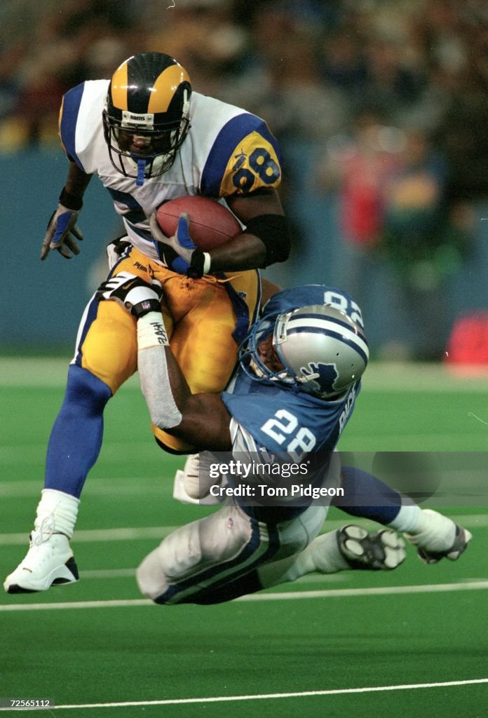 Running back Marshall Faulk of the the St. Louis Rams tries to break... News Photo - Getty Images