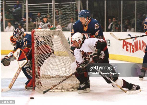 Forward Bob Corkum of the Phoenix Coyotes handles the puck behind the net as he attempts a wrap around shot while gaolkeeper Grant Fuhr of the St....