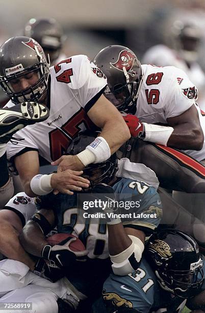 Running back Fred Taylor of the Jacksonville Jaguars is tackled by John Lynch of the Tampa Bay Buccaneers during a game at the Alltel Stadium in...