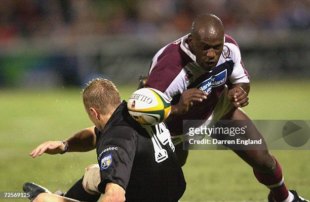 Wendell Sailor of Queensland loses the ball in front of Gus Therons of the Stormers during the Super 12 Rugby Union match between the Queensland Reds...