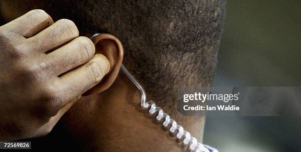 Secret service agent protecting President George W. Bush adjusts his earpiece as he waits on the steps of 10 Downing Street, November 20 in London....