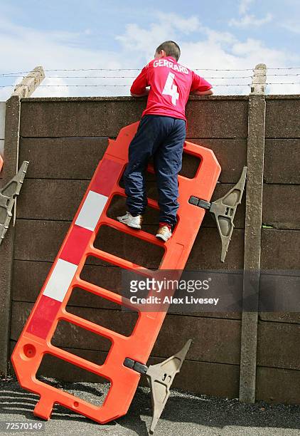 Liverpool fan uses a roadwork barrier to get a glimpse of the Liverpool team training session ahead of the Champions League Semi Final Second Leg...