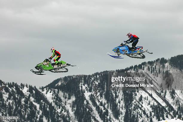 Tucker Hibbert of the USA and Michael Island of the USA sail over a mountain in Snowmobile SnoCross Event during the Winter X-Games VII at Buttermilk...