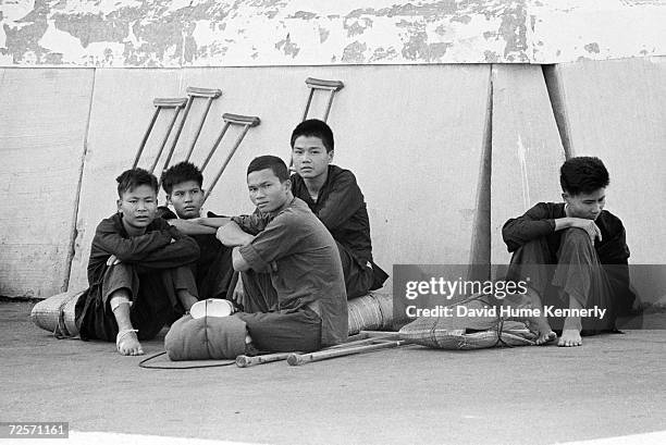 Wounded Viet Cong prisoners of war sit by their crutches in 1973 in Bien Hoa, Vietnam.