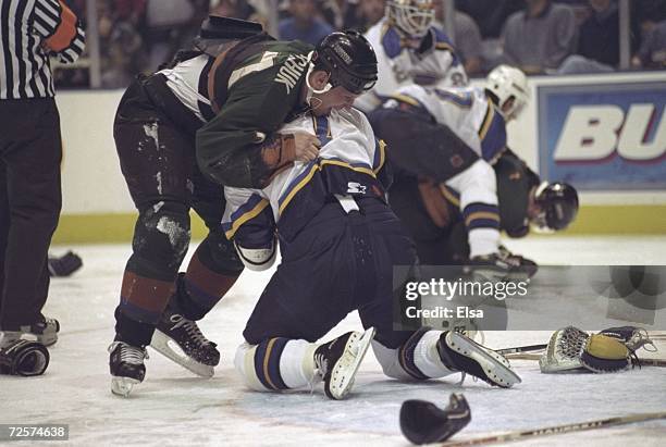 Keith Tkachuk of the Phoenix Coyotes fights with Richard Persson of the St.Louis Blues at the Kiel Center in St.Louis, Missouri. The Coyotes defeated...