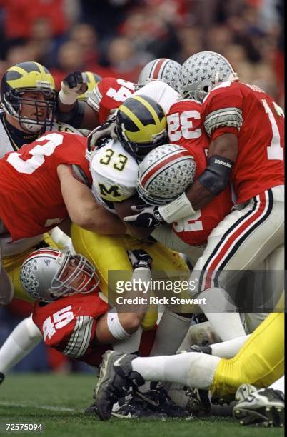 Clarence Williams of the Michigan Wolverines is tackled by Andy Katzenmoyer of Ohio State at Ohio Stadium in Columbus, Ohio. Ohio State defeated...