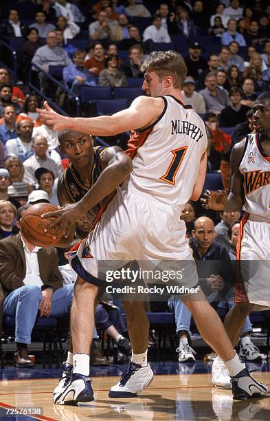 Guard Ron Artest of the Indiana Pacers passes around forward Troy Murphy of the Golden State Warriors during the NBA game at the Arena in Oakland in...