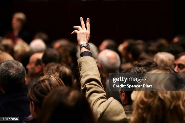 Man holds his hand up while bidding on a work of art inside the auction house Christie's during the Post-War and contemporary Art sale November 15,...