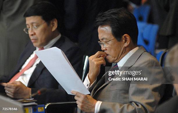 Japanese Foreign Minister Taro Aso reads a document prior to the Asia-Pacific Economic Cooperation 's ministeral meeting 16 November 2006 in Hanoi....