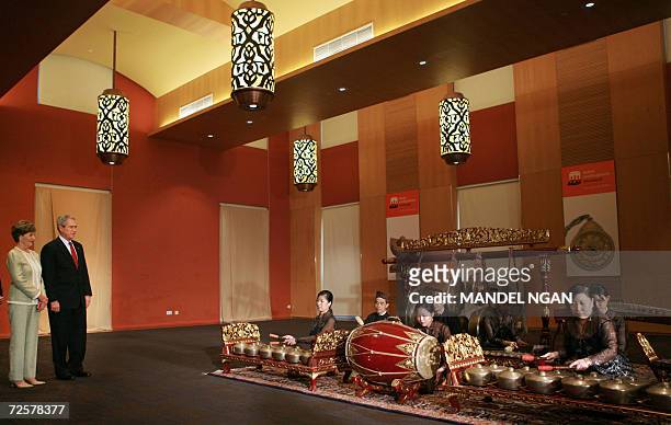 President George W. Bush and First Lady Laura Bush watch a gamalon orchestra perform during a tour of the Asian Civilisations Museum 16 November 2006...