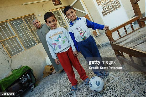 Iraqi patriarch Khudair al-Khafaji and grandsons Ali and Hassa pose as they finish rebuilding the family home, nearly one year after a double suicide...