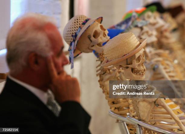 Man sits next to skeletons at the Plastinarium workshop and showroom during the inauguration of Gunther von Hagens' Plastination Factory, on November...