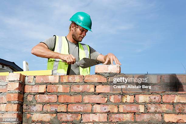 building worker laying bricks - maçon photos et images de collection