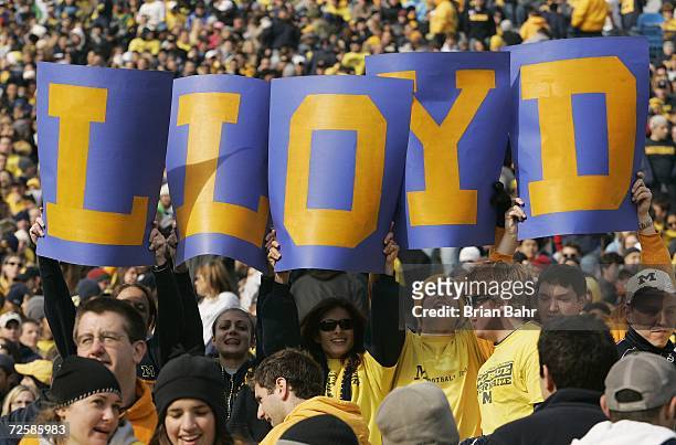 Fans hold up cards which spell "Lloyd", in reference to head coach Lloyd Carr of the Michigan Wolverines during the NCAA football game against the...