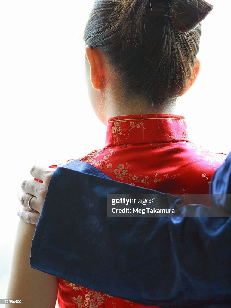 Rear view of a man's hand on a woman's shoulder