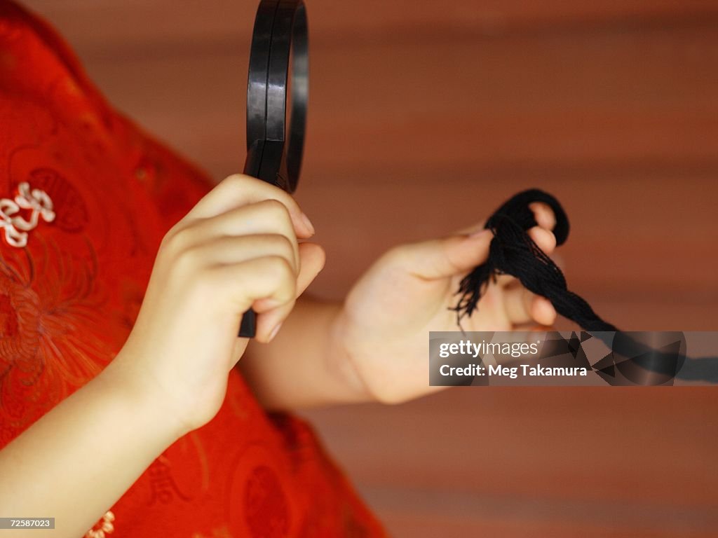Mid section view of a girl holding a magnifying glass