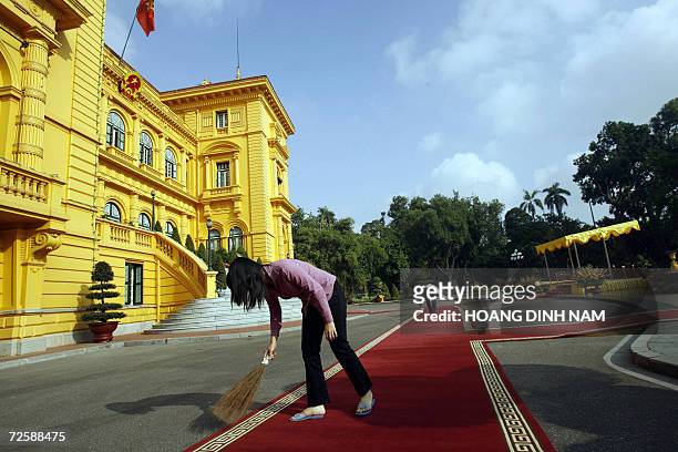 Workers sweep out dust from the red carpet laid down in the courtyard of the presidential palace ahead of the welcoming ceremony for US President...