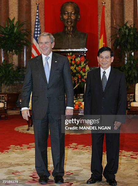 President George W. Bush and Vietnamese President Nguyen Minh Triet pose infront a bust of Ho Chi Minh during a meeting 17 November 2006 at the...