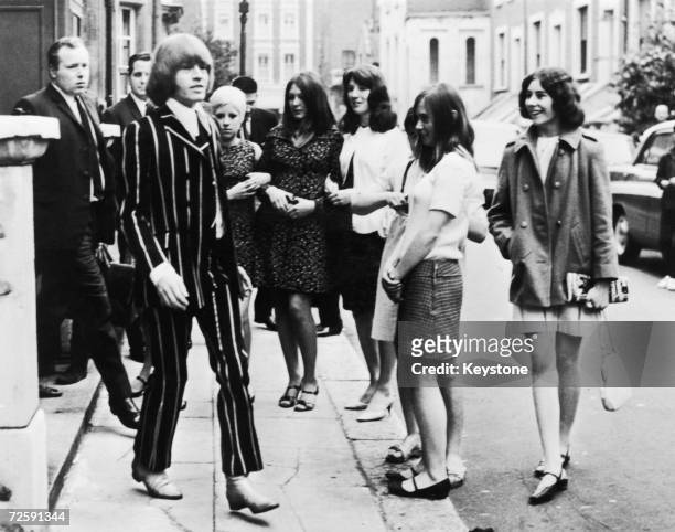 Watched by a group of fans, Rolling Stones guitarist Brian Jones , leaves West London Magistrate's Court after a hearing on drugs charges, 2nd June...