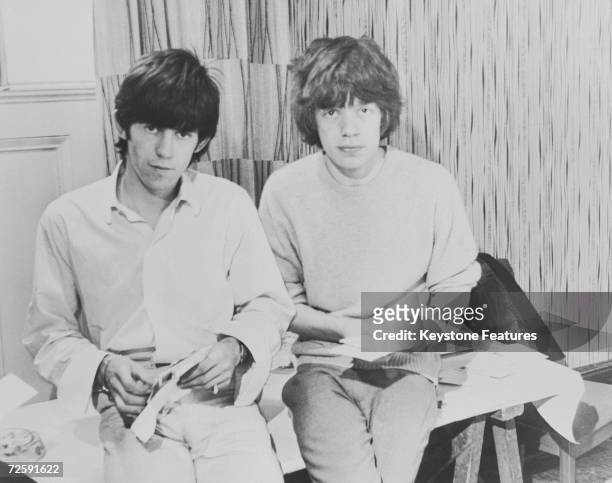 Rolling Stones singer Mick Jagger and guitarist Keith Richards opening fan mail during the early days of the band, circa 1963.