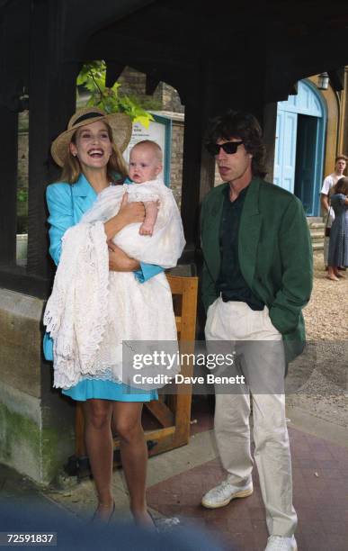 Jerry Hall and Mick Jagger, singer of The Rolling Stones, pose with their daughter Georgia May Jagger during her christening at Saint Andrew's...