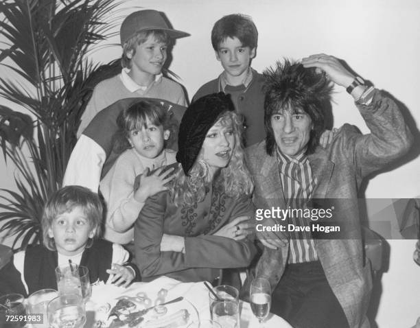 Rolling Stones guitarist Ron Wood with his wife Jo and their children, Jamie, Jesse, Tyrone and Leah, 19th February 1988. The family are dining out...