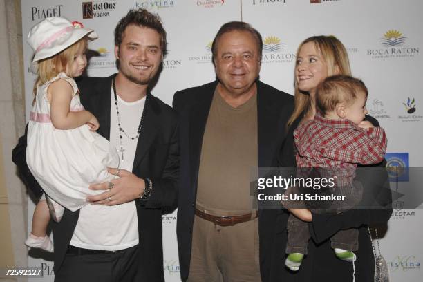 Mira Sorvinos' husband, Christopher Backus holds daughter Mattea Angel while standing next to Paul Sorviono, Mira Sorvino and son Johnny at the...