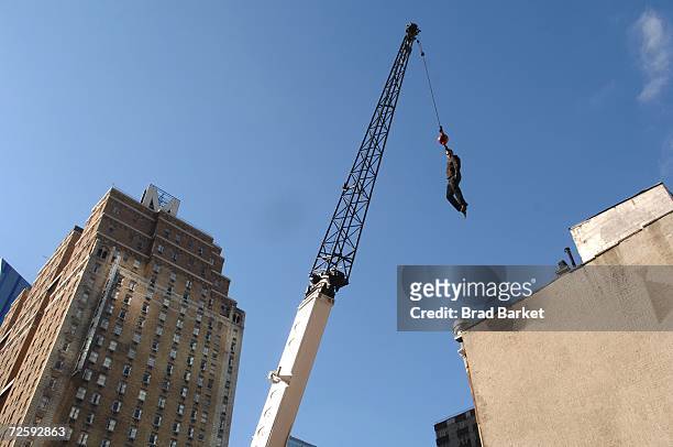 Magician David Blaine hangs from a crane in Times Square on November 17, 2006 in New York City. Blaine announced that his next stunt will be an...