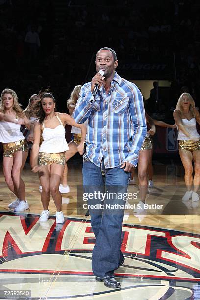 Brian McKnight sings as the New Jersey Nets Dancers perform during the game against the Miami Heat on November 10, 2006 at the Continental Airlines...