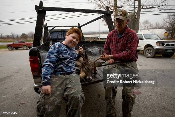 After having a Vermont state wildlife biologist, not shown, note the data from a recently shot whitetail deer, Perle Webb, Sr., right, and his...