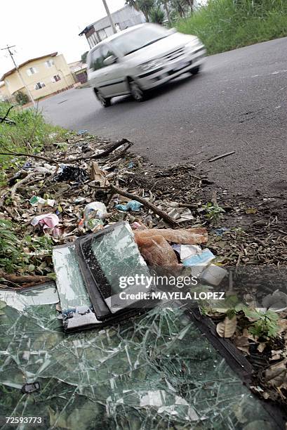 Un automovil transita junto a un tiradero de basura el 17 de noviembre de 2006 en la localidad de Tibas, al norte de San Jose, donde es comun hallar...