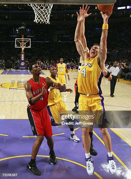 Luke Walton of the Los Angeles Lakers drives to the basket past Chris Bosh of the Toronto Raptors during the first half of the game on November 17,...