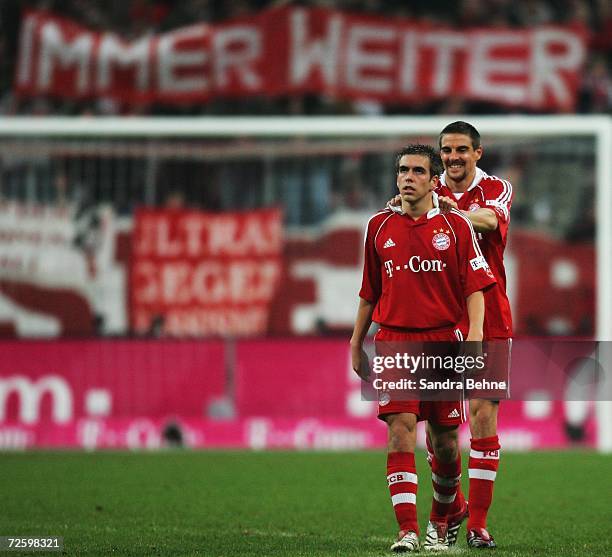 Sebastian Deisler and Philipp Lahm of Bayern Munich celebrate while their fans hold up a banner saying "always forward" after the Bundesliga match...