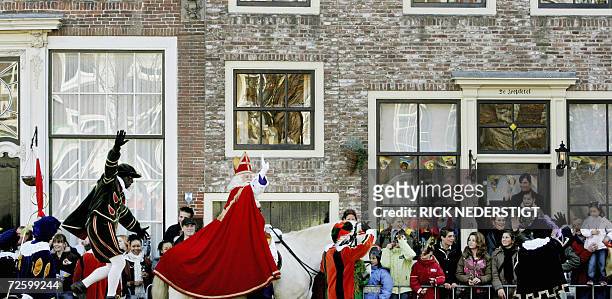 Middelburg, NETHERLANDS: St. Nicholas, on his white horse, waves to children as he arrives in the historical city harbor of Middelburg 18 November...