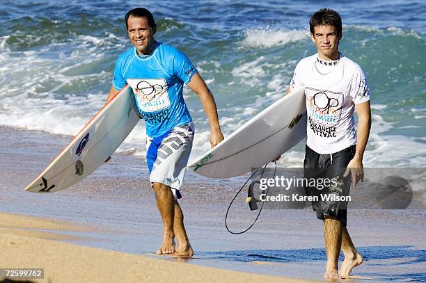 Derek Ho and his nephew Mason Ho walk up the beach during the men's competition of the OP Pro World Qualifying Series part of the Vans Triple Crown...