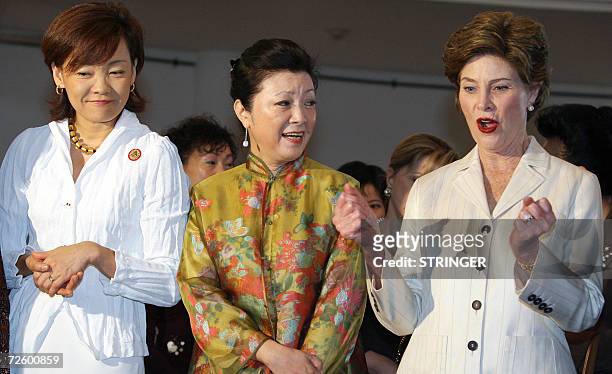 First Lady Laura Bush gestures as Akie Abe from Japan and Mrs. Chang from Taiwan look on during a visit by spouses of Asia Pacific Economic...