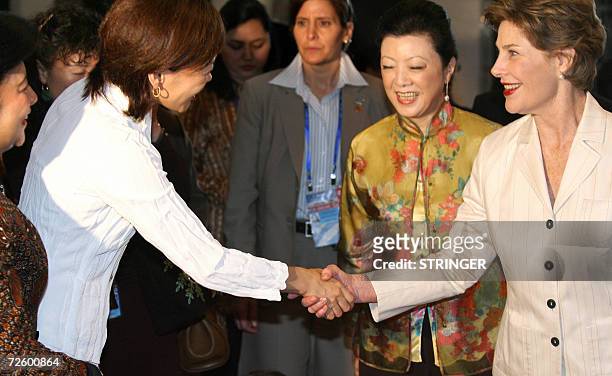 Akie Abe from Japan shakes hands with US First Lady Laura Bush as Mrs. Chang from Taiwan looks on during a visit by spouses of Asia Pacific Economic...